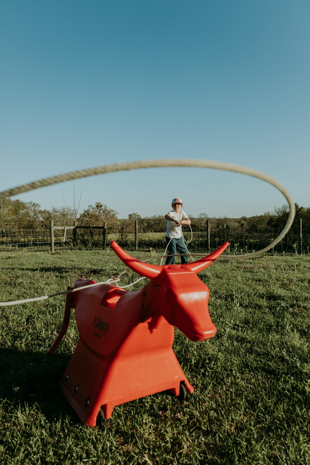 a person standing next to a red toy in a grassy field