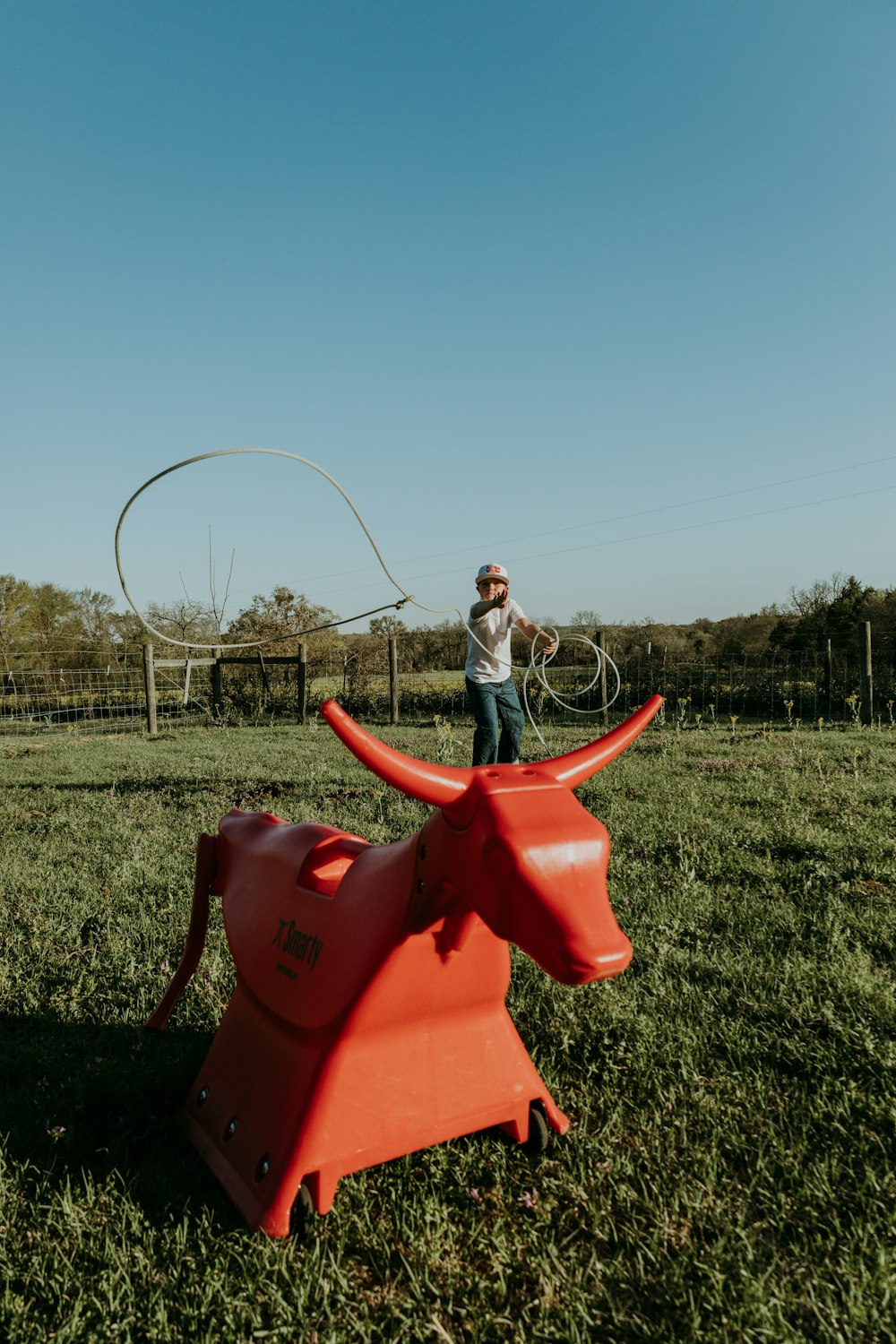 a person standing next to a red lawnmower in a grass field