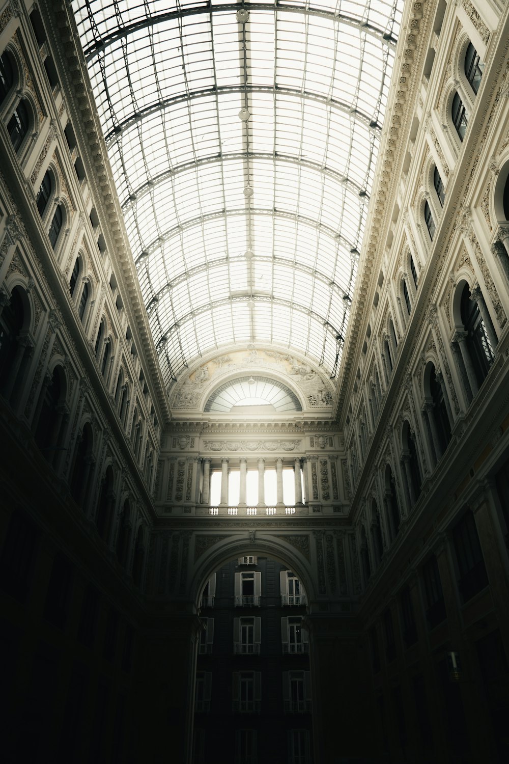 um edifício alto com muitas janelas com Galleria Umberto I ao fundo