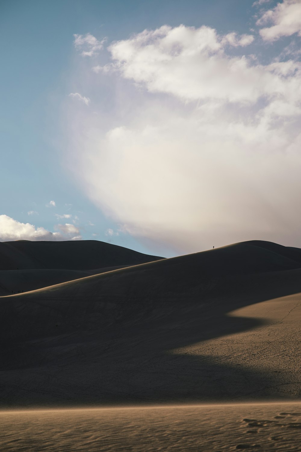 a sandy area with hills in the background