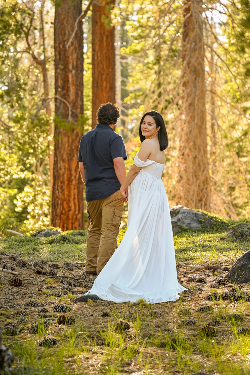 a man and woman walking in the woods