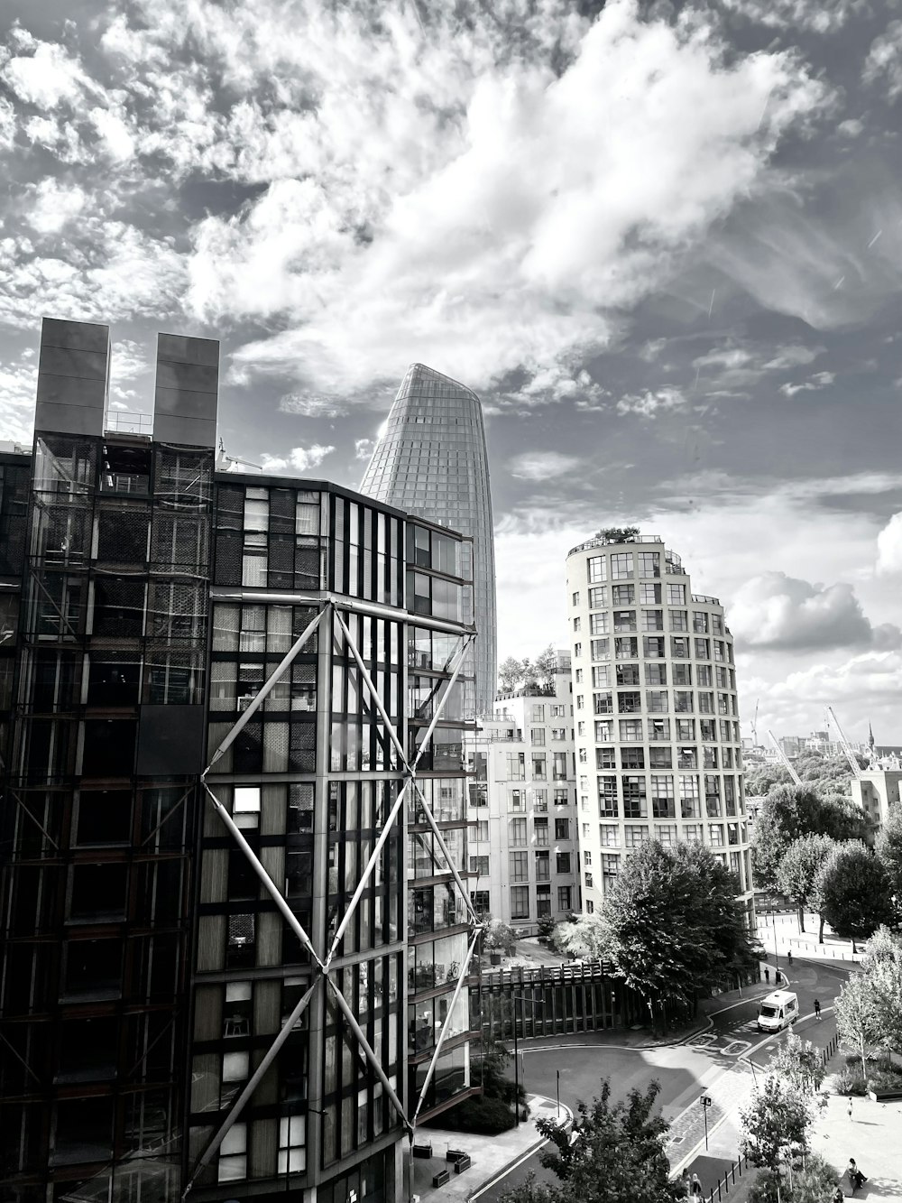 a group of buildings with a road and trees in the front