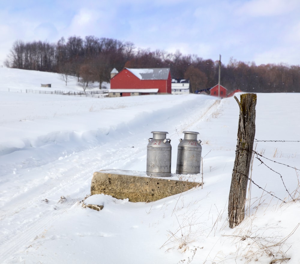 a group of metal containers in a snowy field