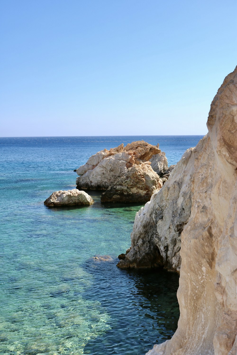 a rocky cliff next to the ocean