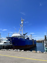 A rugged fishing boat docked at Algoma harbor under a clear blue sky.