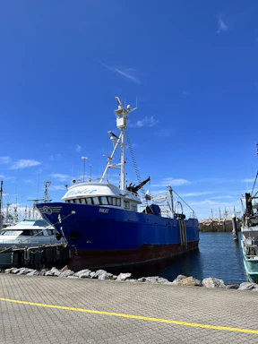 A rugged fishing boat docked at Algoma harbor under a clear blue sky.