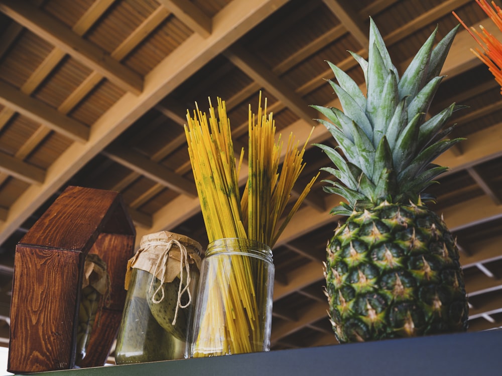 a couple of pineapples in a glass vase