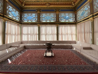 a room with a red carpet and a large chandelier