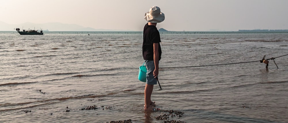 une personne tenant une canne à pêche sur une plage
