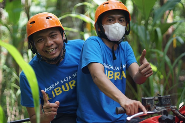 Smiling customer wearing a helmet, standing next to a freshly serviced ATV.