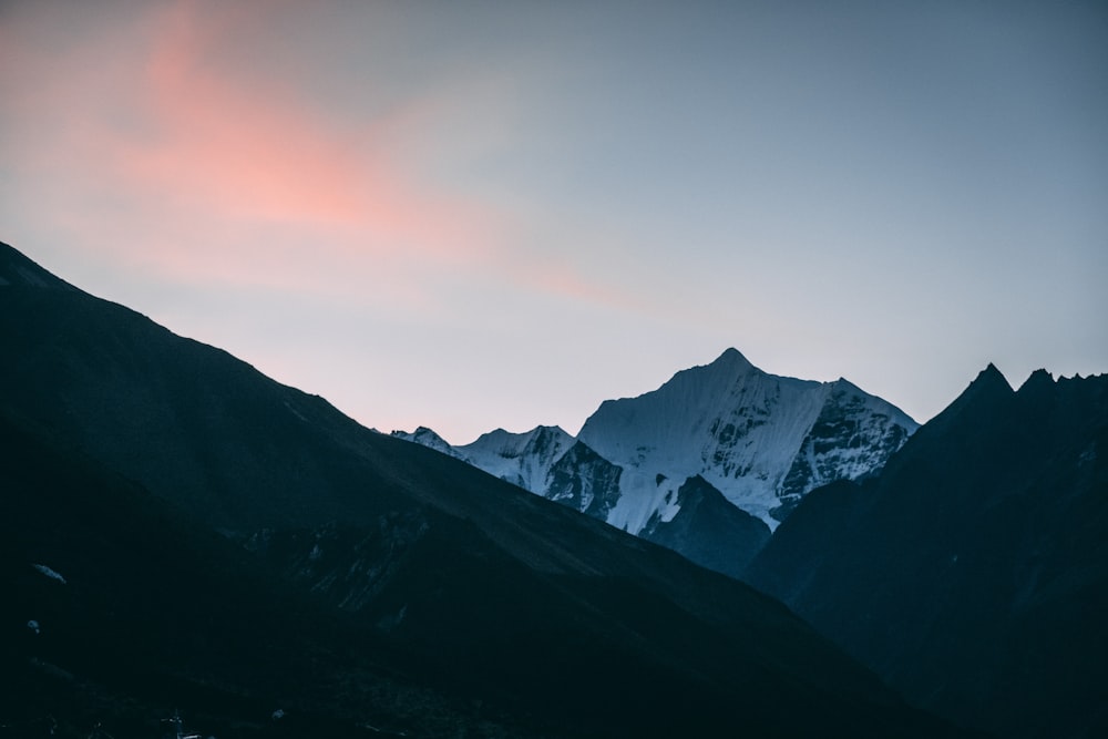 a mountain range with a pink and purple sky