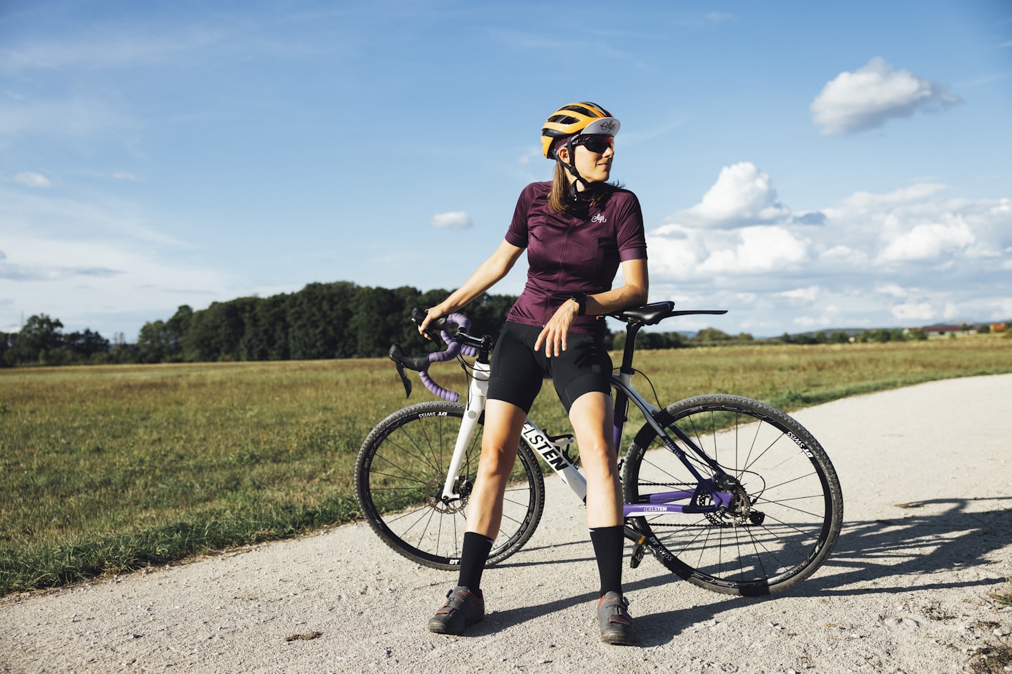 Sporty female cyclist leaning on a modern gravel bike