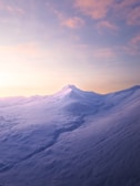 Soft pastel-hued snowy mountain with faint yin-yang symbol overlay.