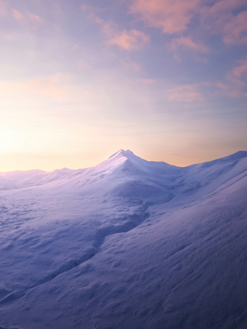 a snowy mountain with a sunset