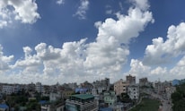 A vibrant cityscape showing residential and commercial buildings under a bright sky.