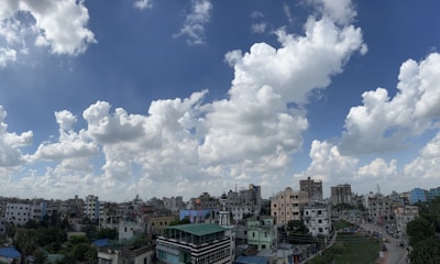 A vibrant cityscape showing residential and commercial buildings under a bright sky.