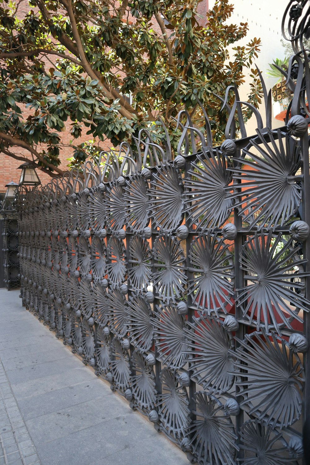 a metal fence with a tree in the background