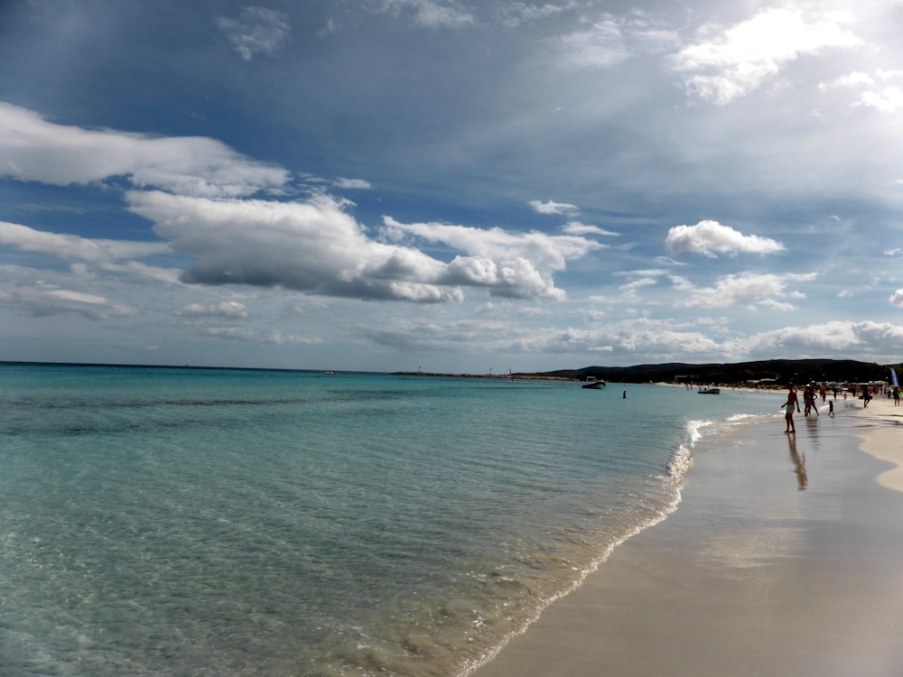 a beach with people walking on it