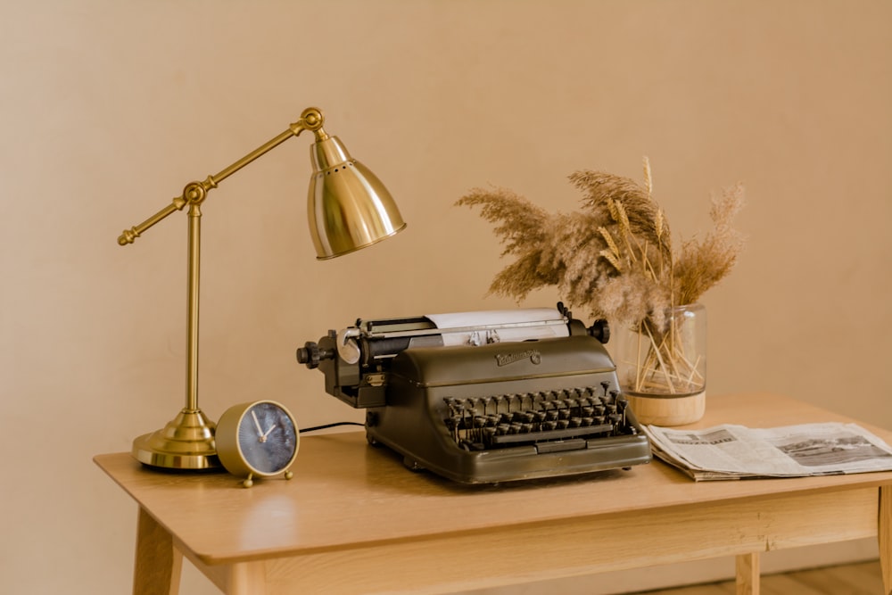 a typewriter and a lamp on a table