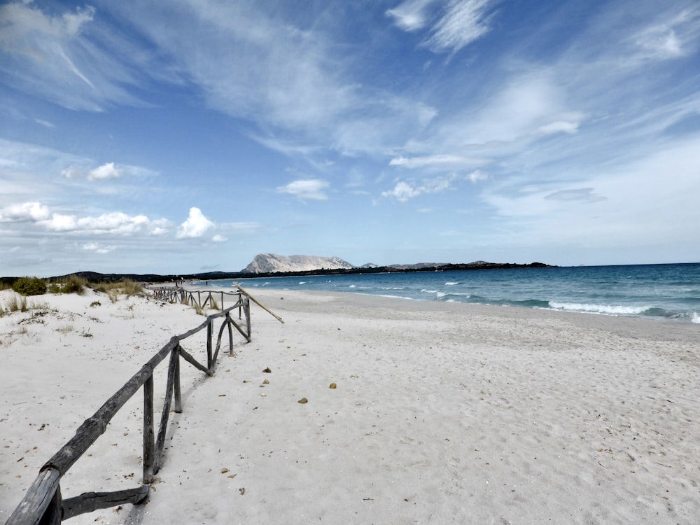 a sandy beach with a railing