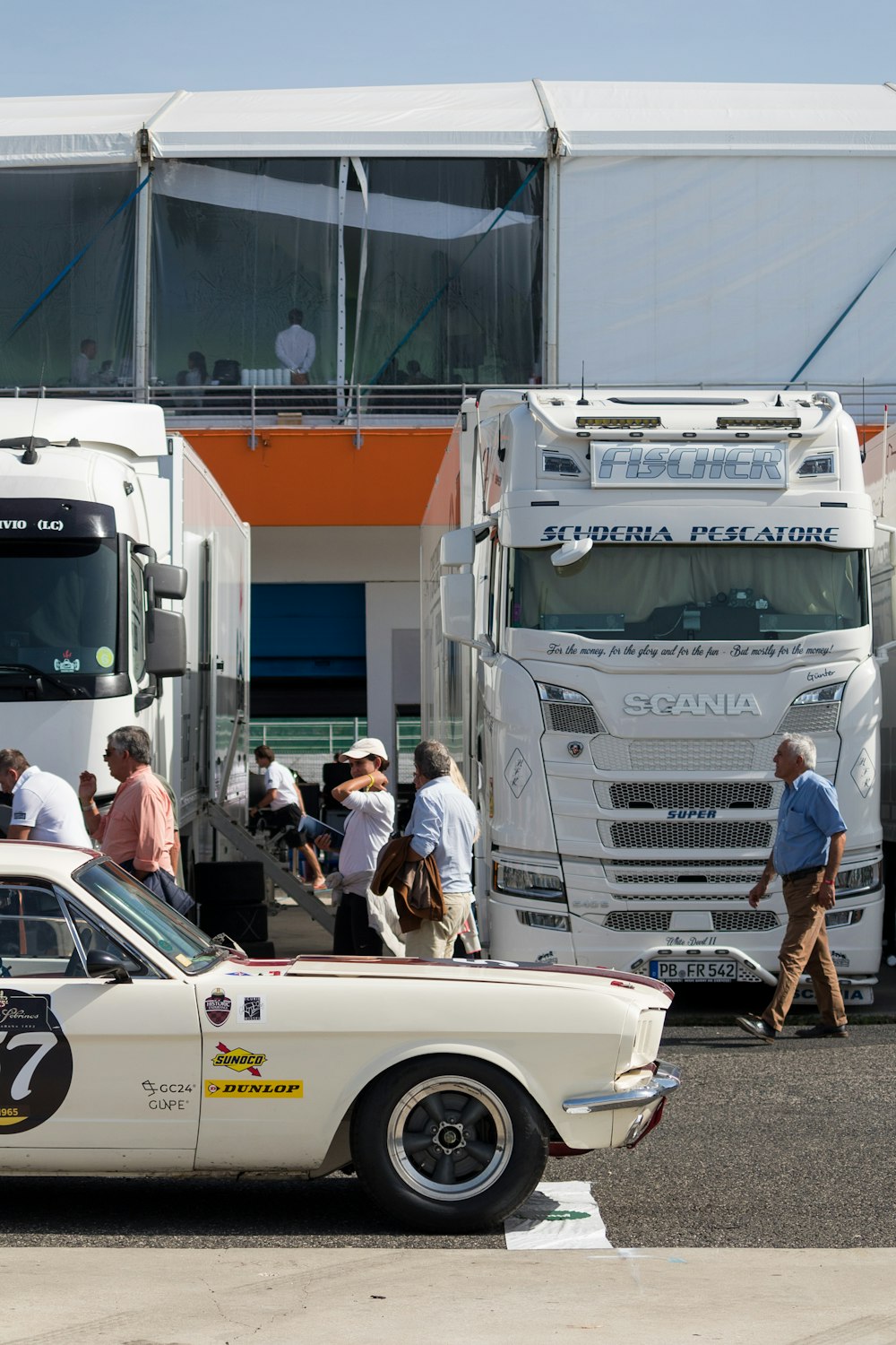 Un groupe de personnes debout à côté d’un camion blanc