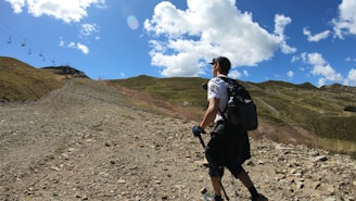 A hiker wearing outdoor gear on a mountain trail.
