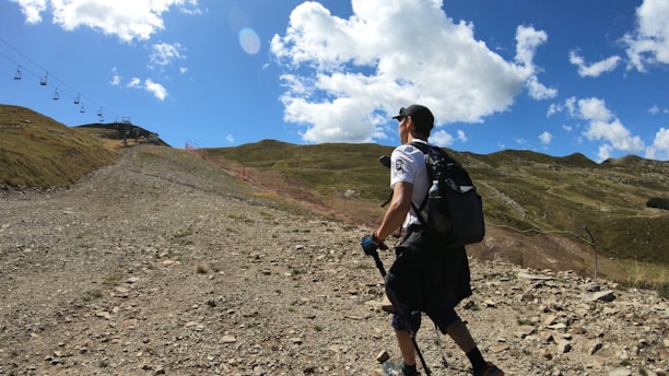 A hiker wearing outdoor gear on a mountain trail.