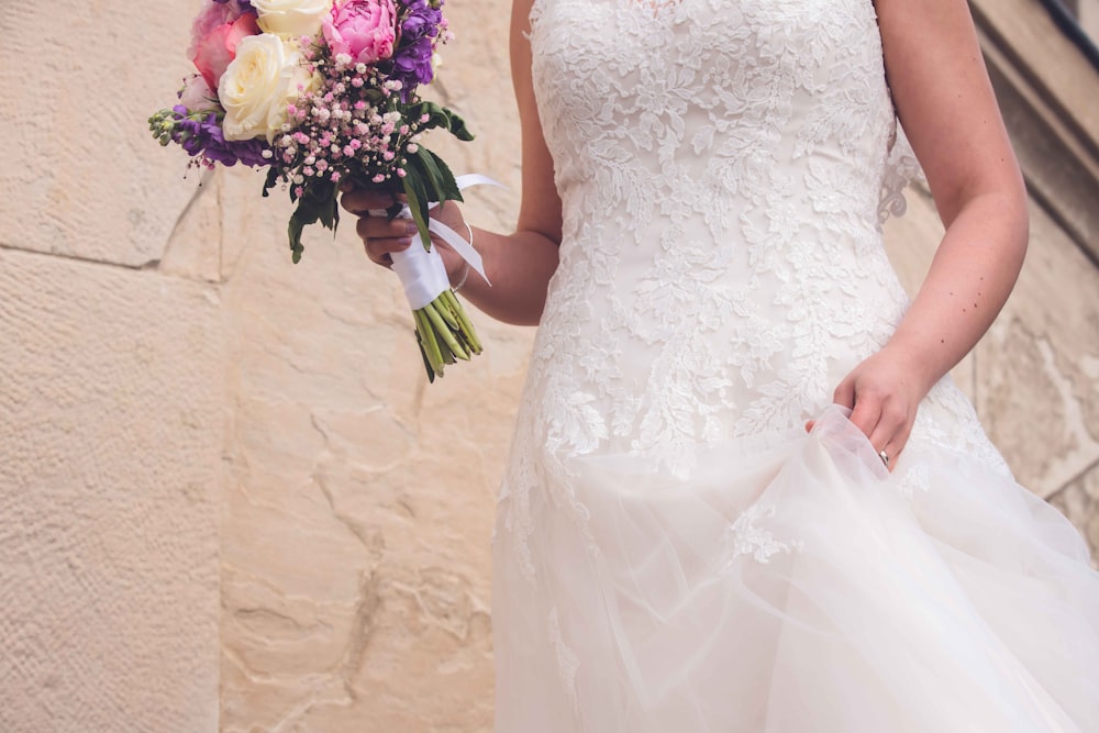 a woman in a white dress holding flowers