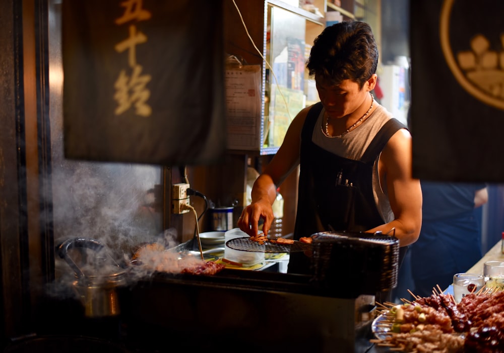 um homem cozinhando comida em uma churrasqueira em um restaurante