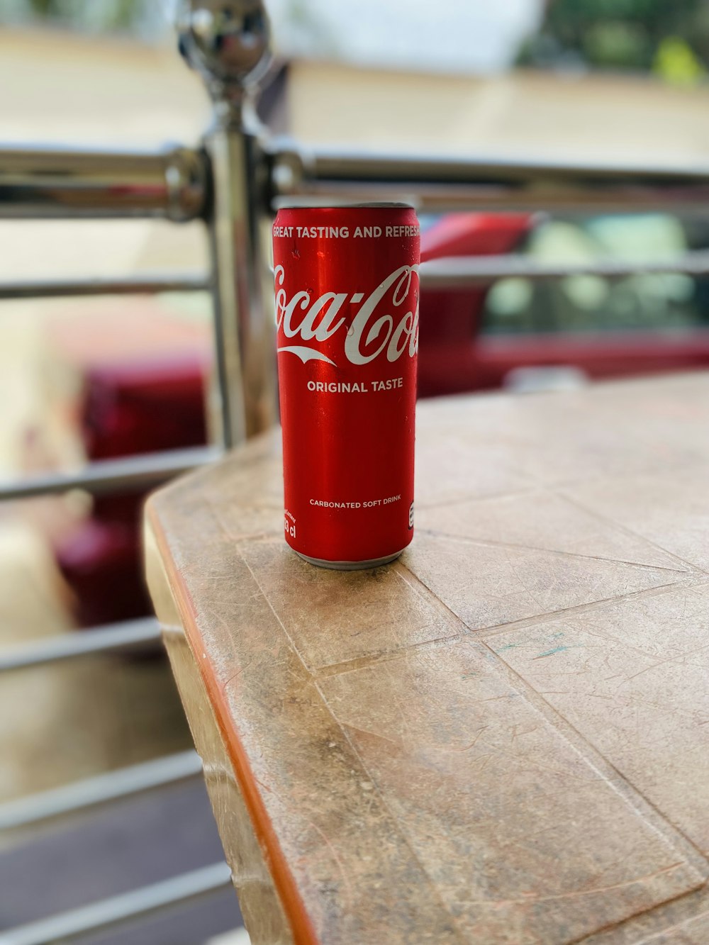 a red can of soda on a wooden table