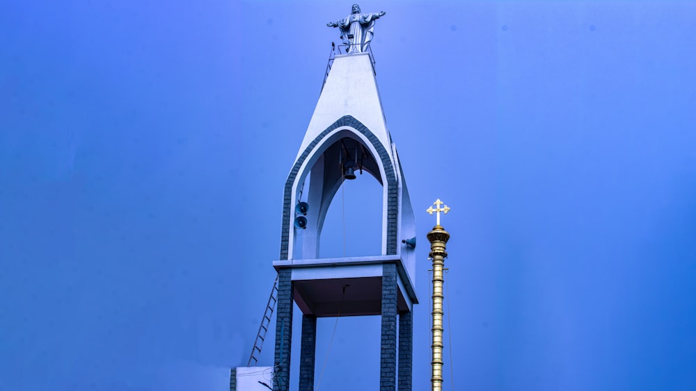 a tall white tower with a cross on top
