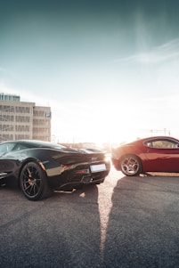 A sleek car and motorcycle parked side by side in a minimalist urban setting at sunset.