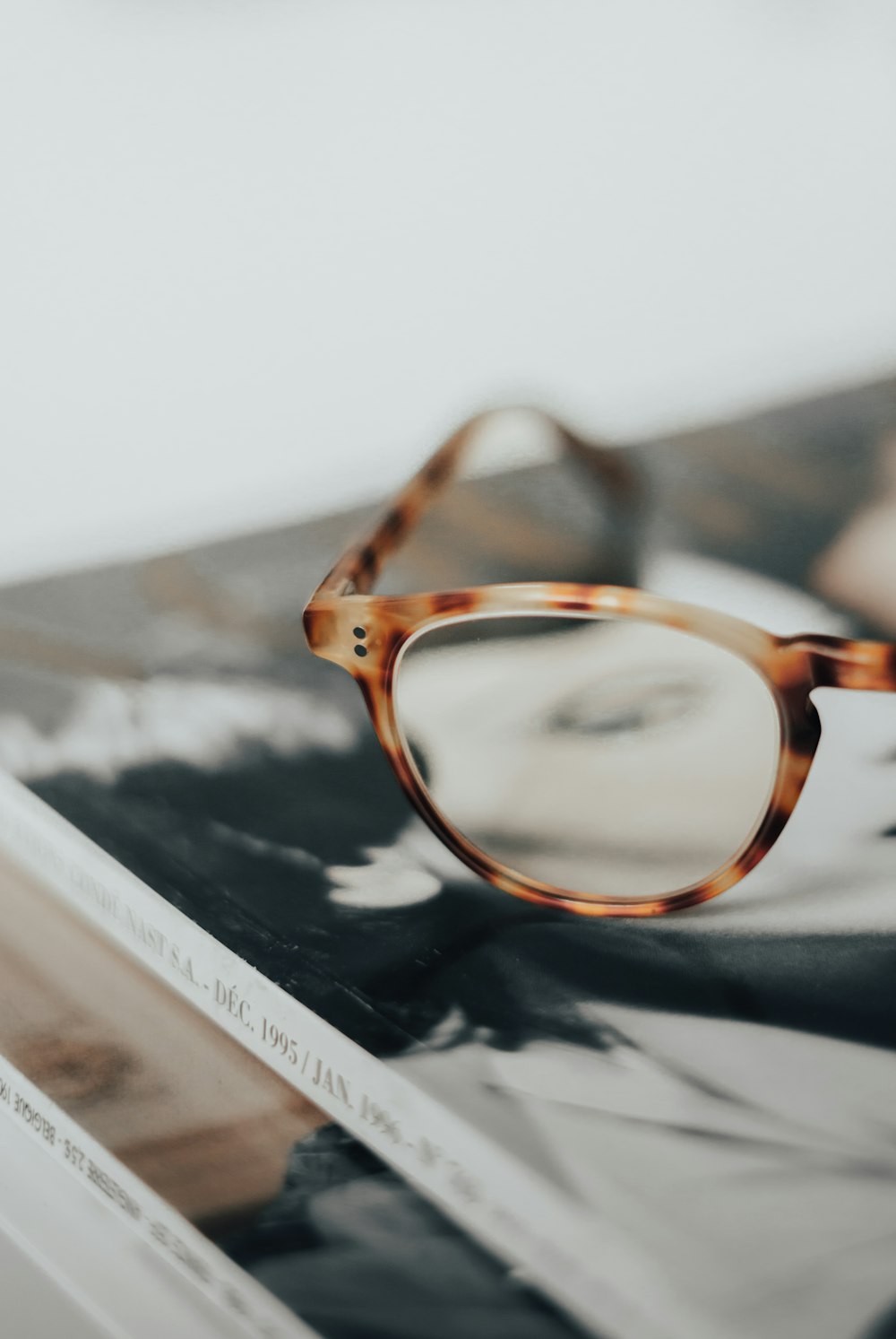 a pair of glasses on top of a pile of papers