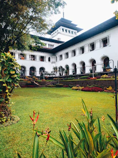 a large white building with a garden in front of it