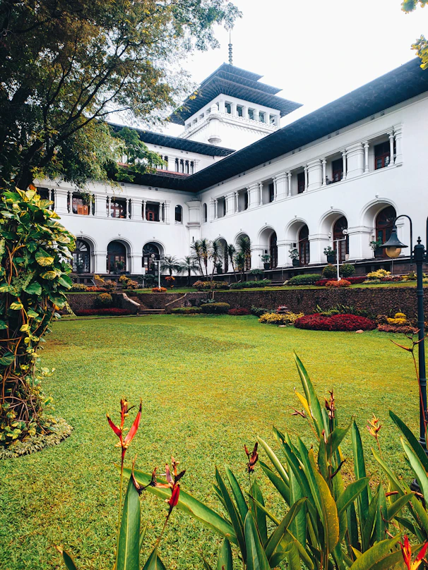 a large white building with a garden in front of it