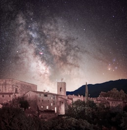 a city with a large tower and a starry sky