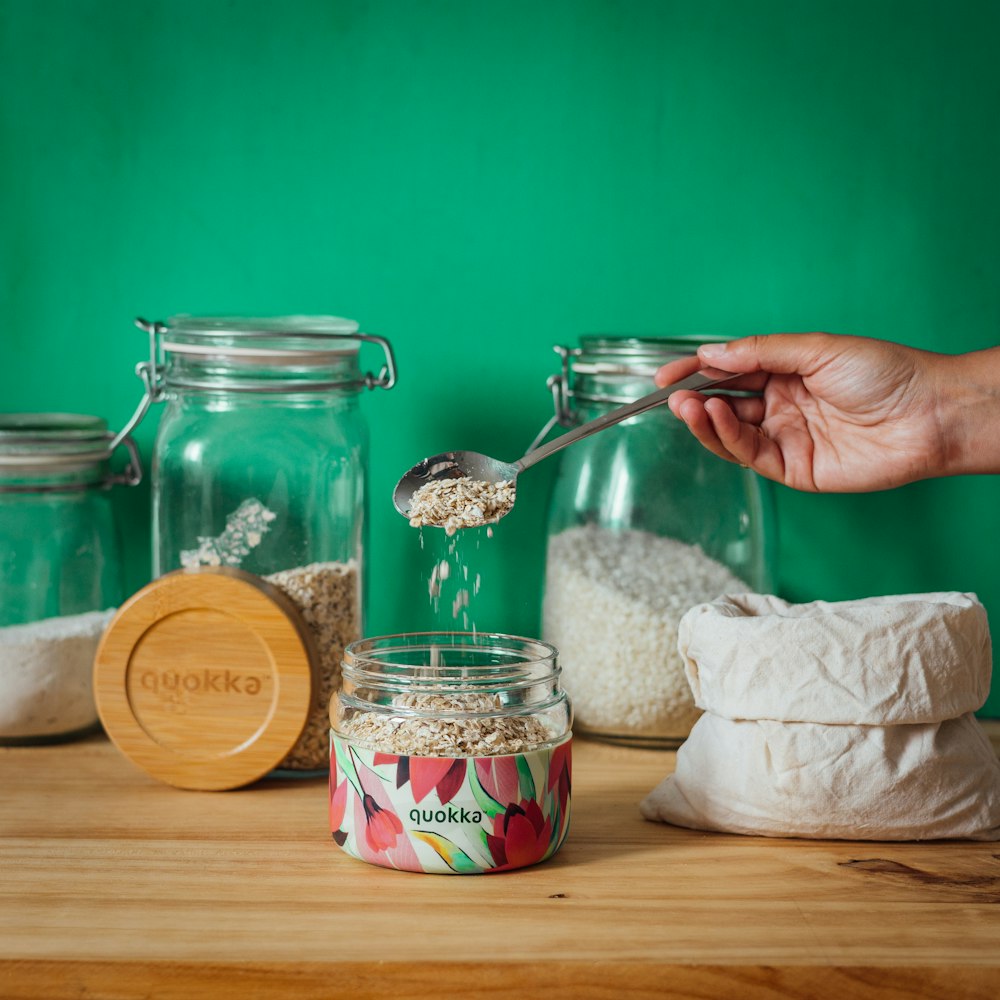 a person pouring a jar of food