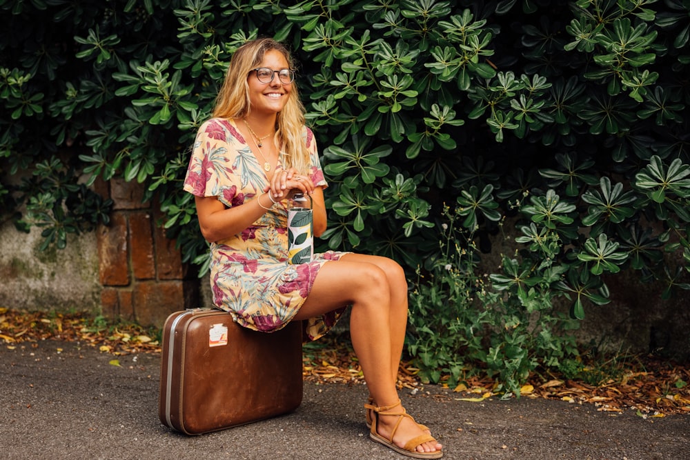 a person sitting on a suitcase