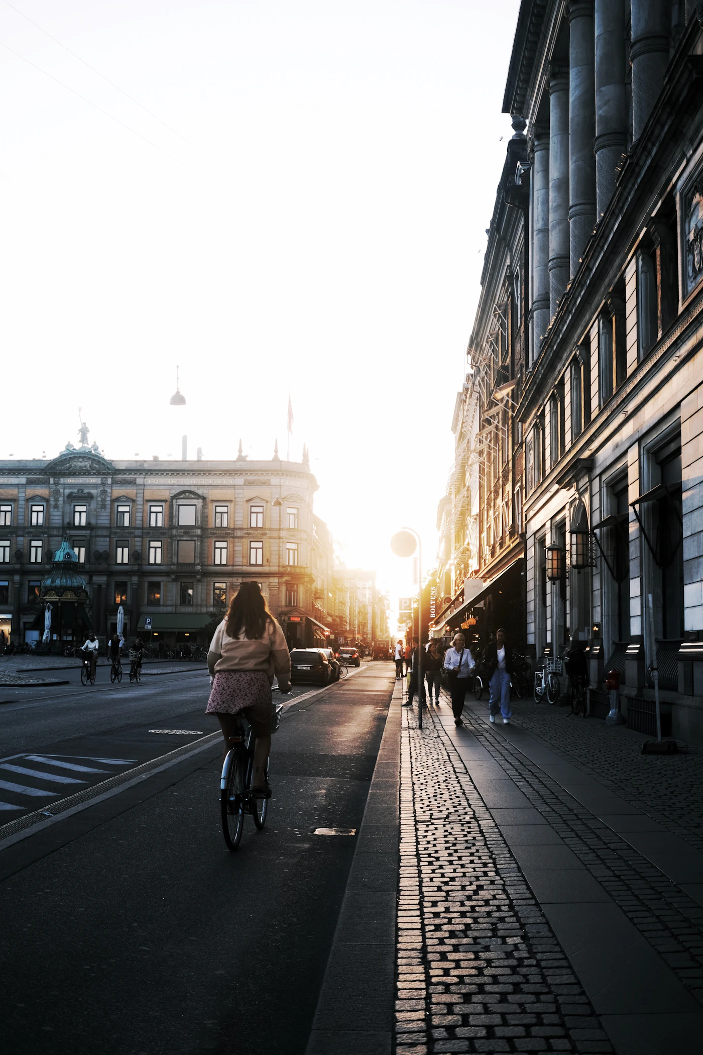 Cyclist moving through a sunlit Copenhagen street