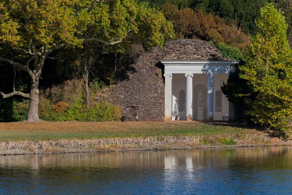 a building with columns by a body of water