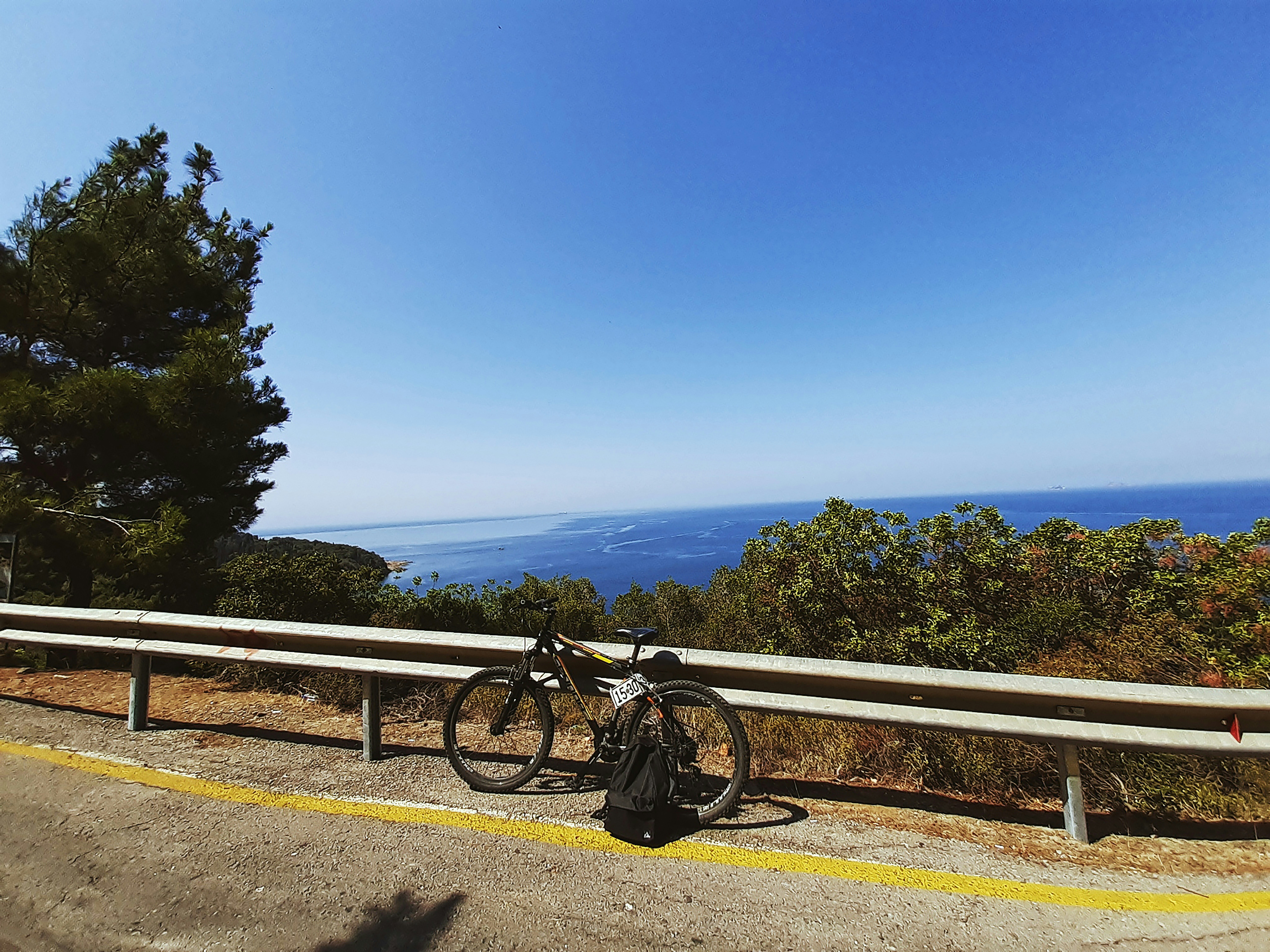 a bicycle parked on a railing overlooking a body of water
