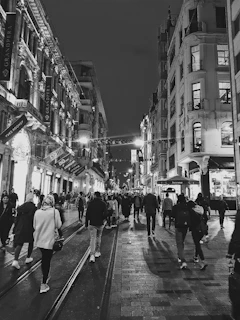 A lively city street at night, full of lights and travelers exploring.