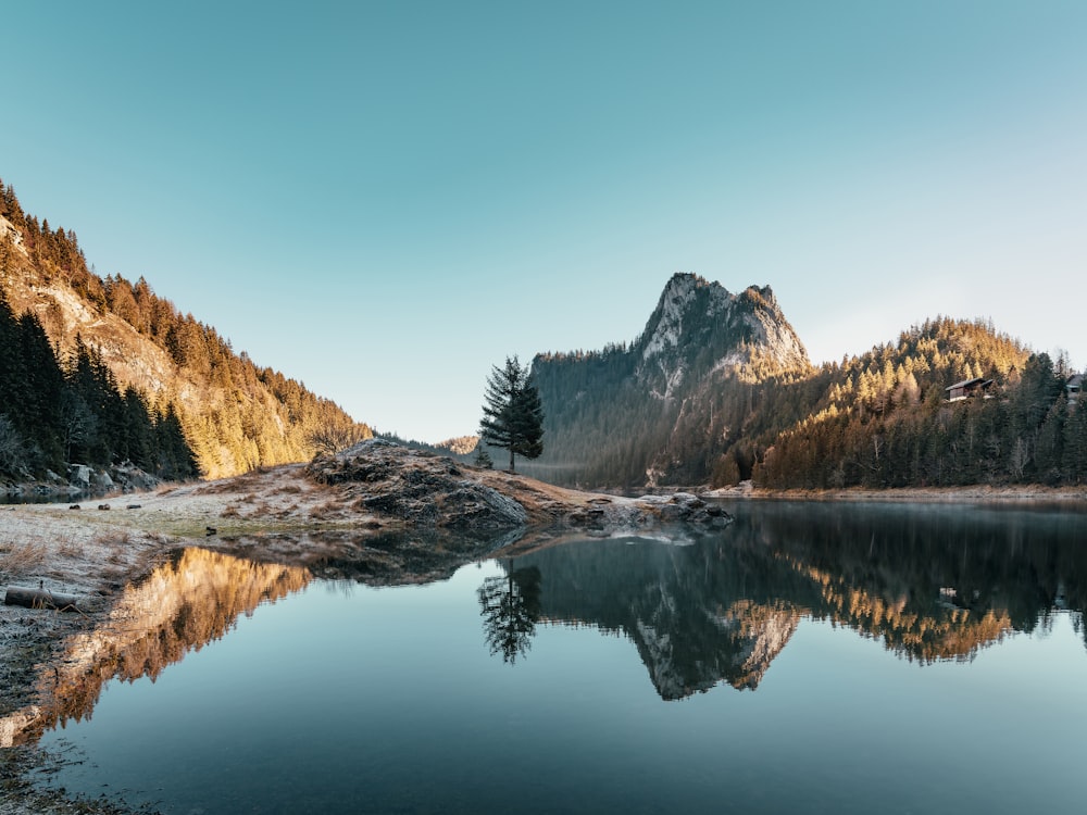 a lake with trees and mountains in the background