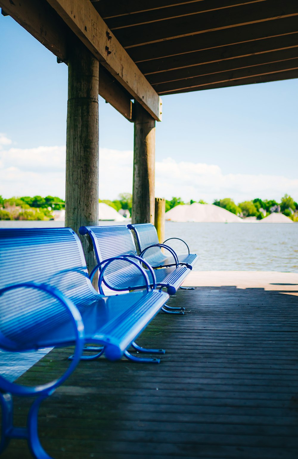a row of blue benches on a dock