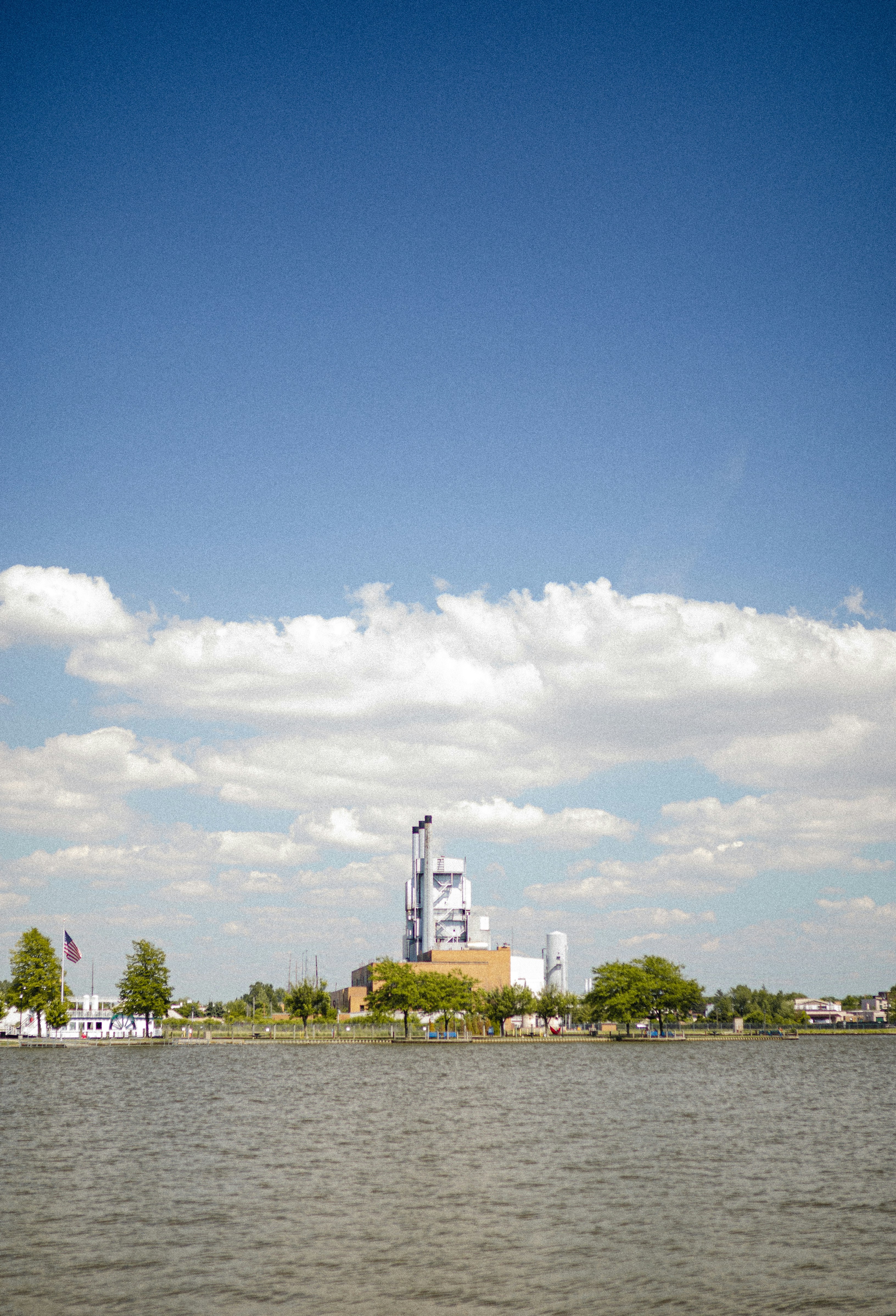 a body of water with buildings and trees in the background