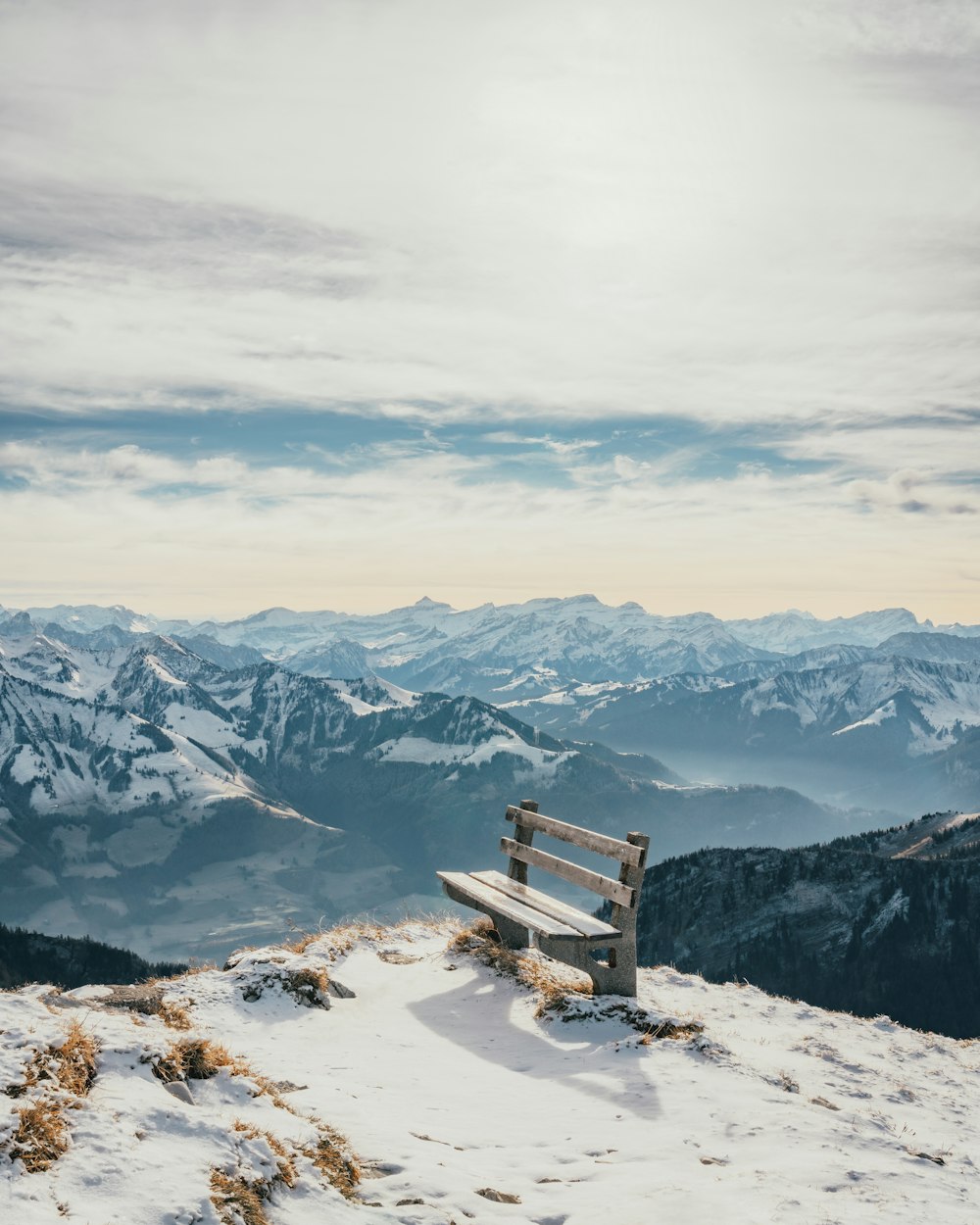 a bench sits on a snowy mountain