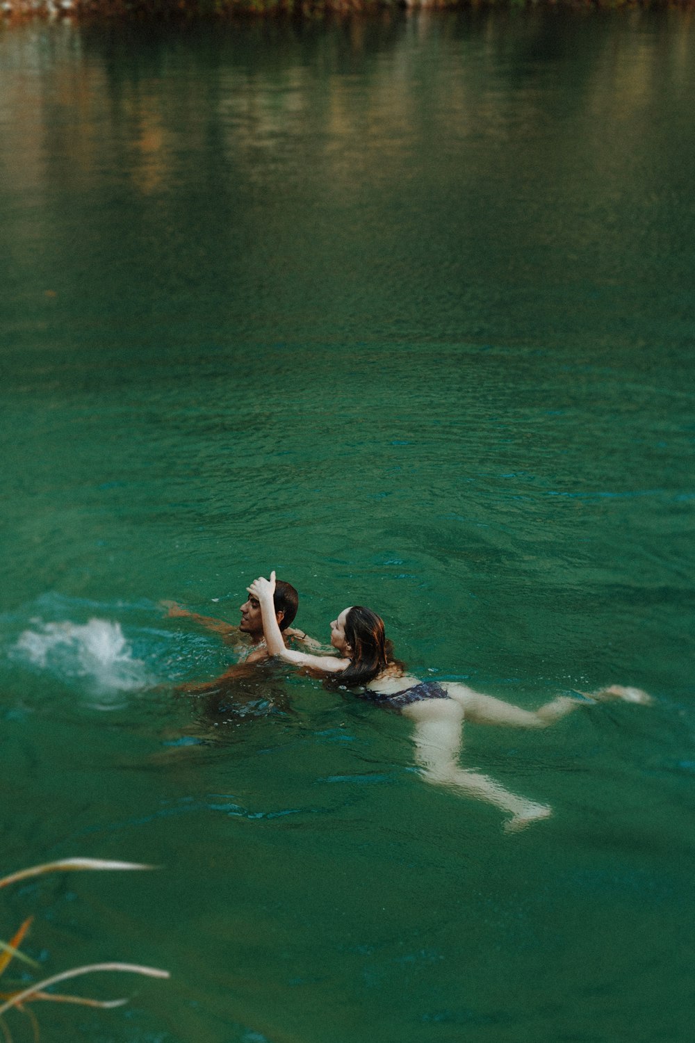 two people swimming in water