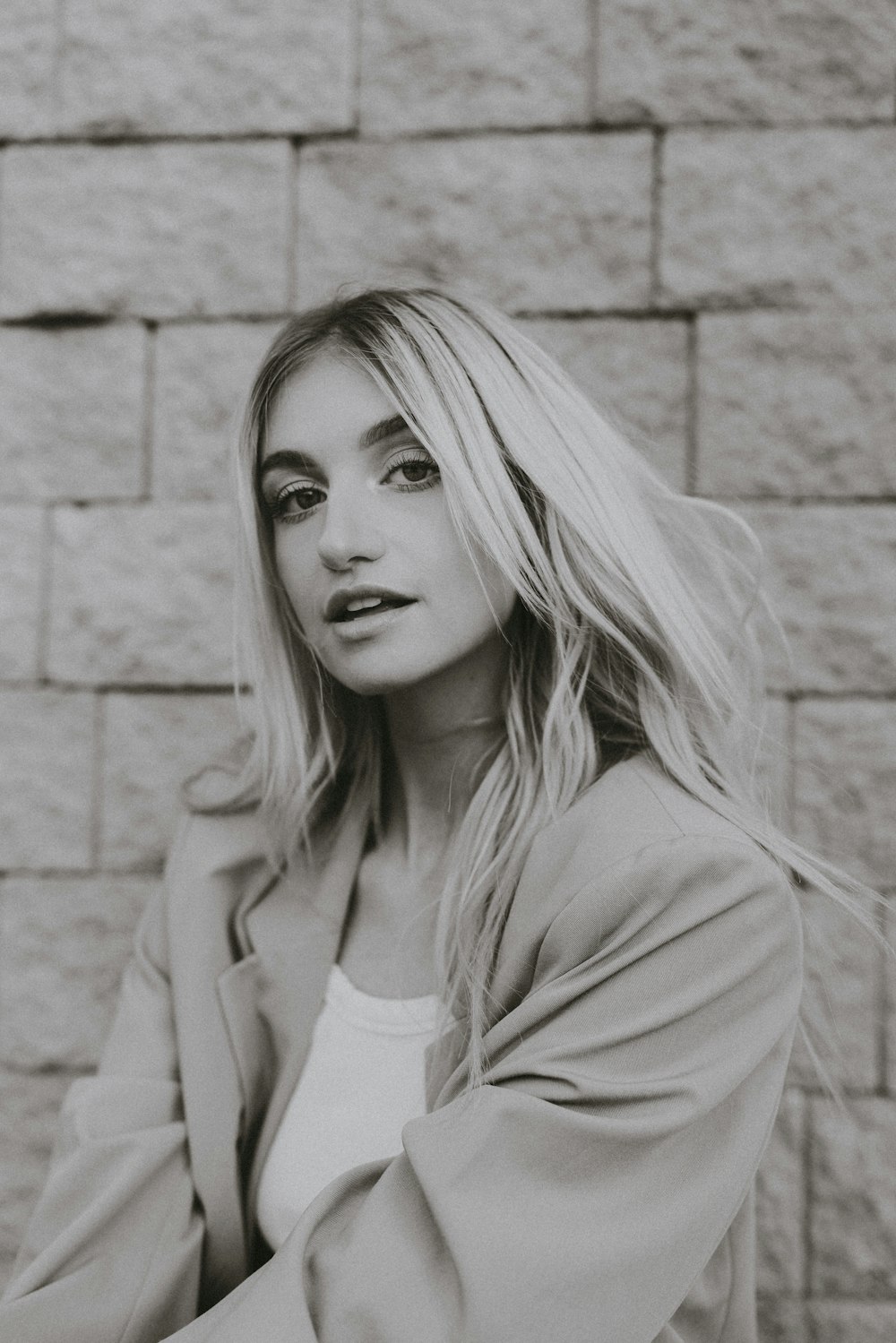 a woman leaning against a wall