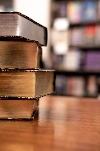 Close-up of bestselling books stacked on a wooden table.