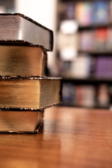 Close-up of legal books stacked on a wooden desk.